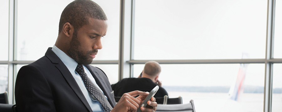 Businessman looking at smartphone at airport