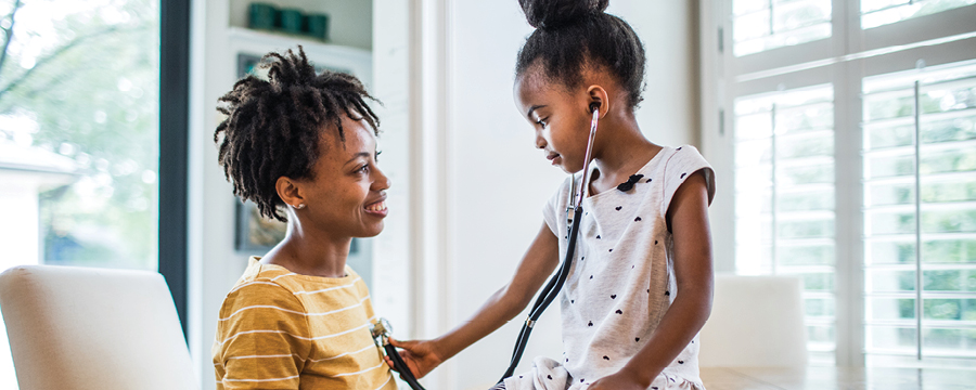 Daughter using  stethoscope on mother.