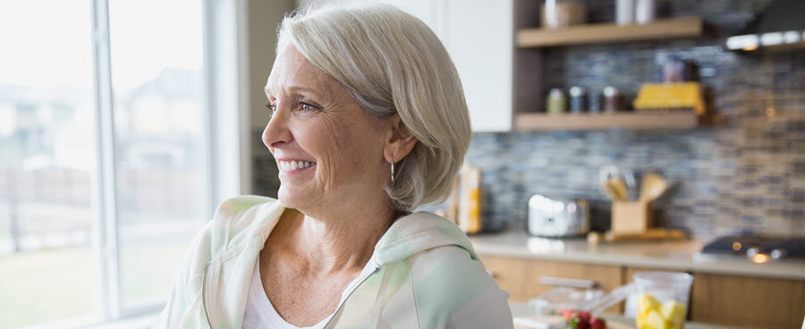 A close-up of a woman smiling in her kitchen