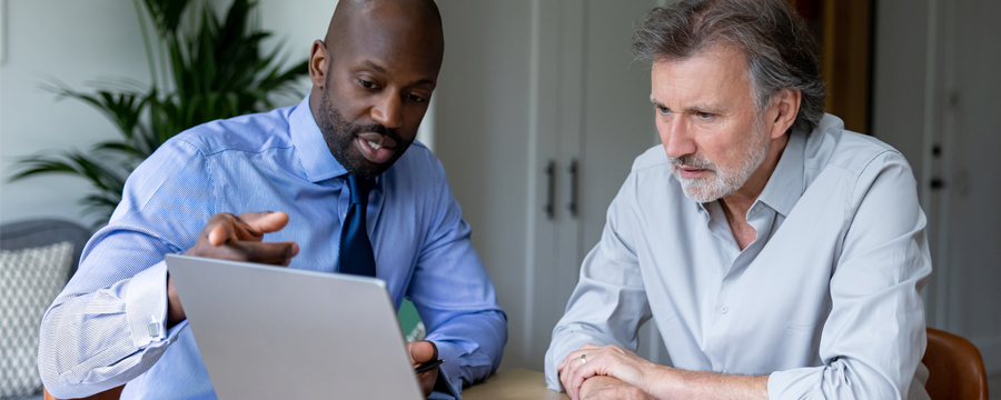 Financial advisor showing a client something on a laptop.