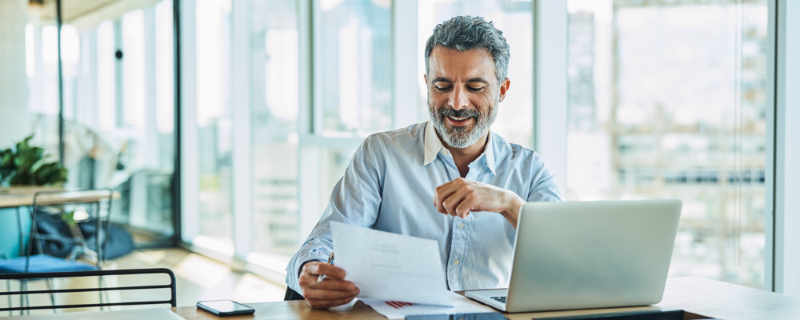 Man reviewing documents at his workspace.